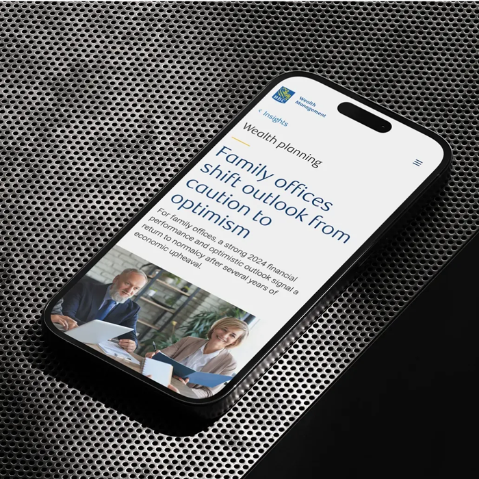 A smartphone displays an article titled Family offices shift outlook from caution to optimism, highlighting insights drawn from trew knowledge.