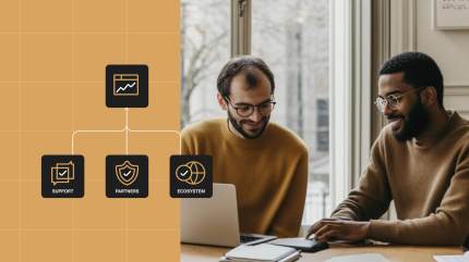 Two colleagues in matching brown sweaters are collaborating over a laptop at a table near a window. In the left corner of the image, icons representing support, partners, and digital ecosystem are connected with lines, symbolizing the integrated approach WordPress VIP uses to drive high site performance.