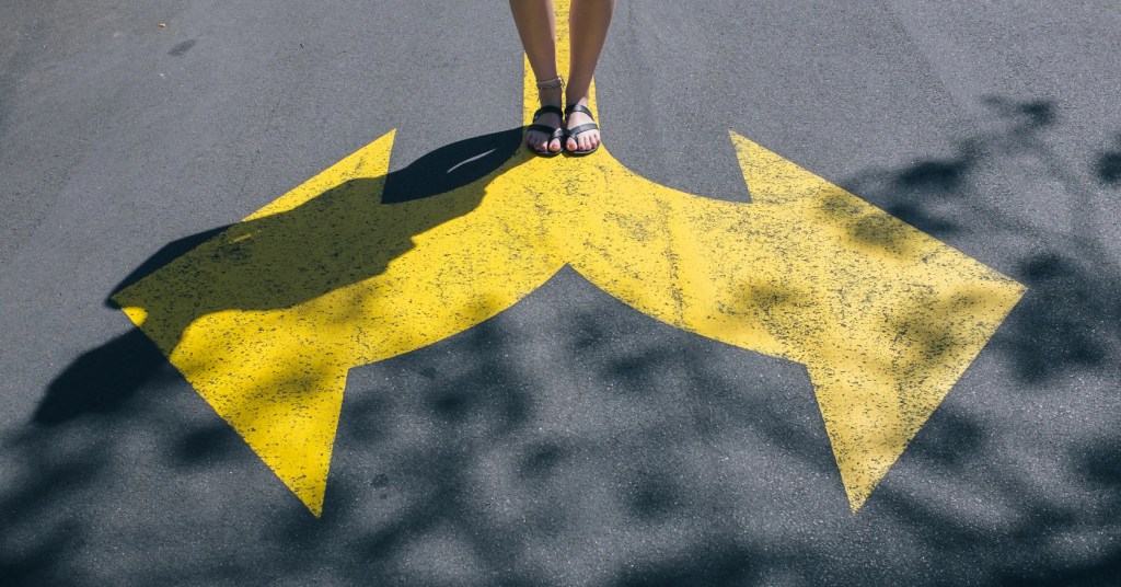 User choosing between options for a digital solution, represented by large directional arrows on the pavement.