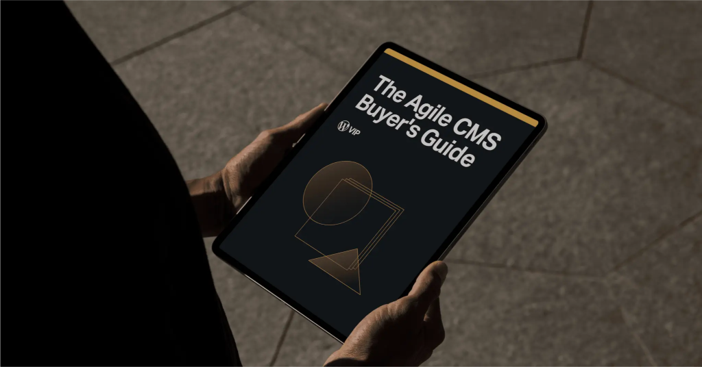 Person holding a tablet displaying The Agile CMS Buyers Guide with geometric shapes on the cover.