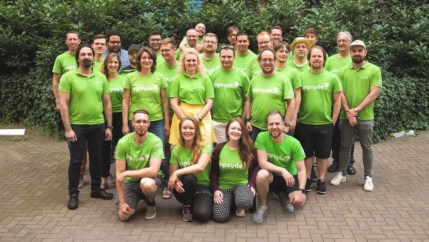 Team smiling together, representing collaboration and content workflow on a digital solution platform.