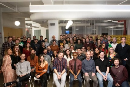 Team celebrating content publishing success on a digital solution platform during a group photo.