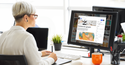Woman with short hair and glasses edits content on a digital solution publishing dashboard.