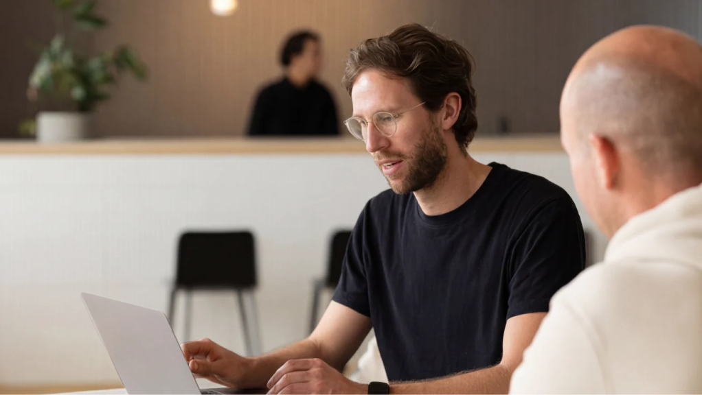 Person using a laptop during a meeting with a colleague.