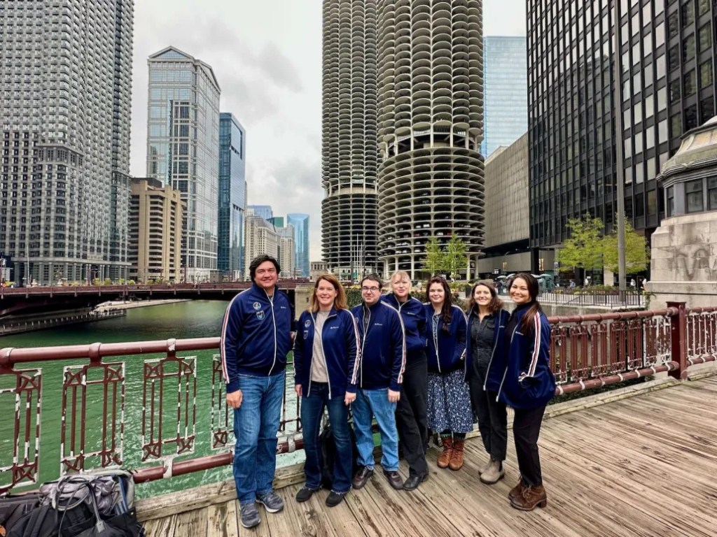 Six team members on a riverwalk showcase digital solution collaboration and content workflow integration.