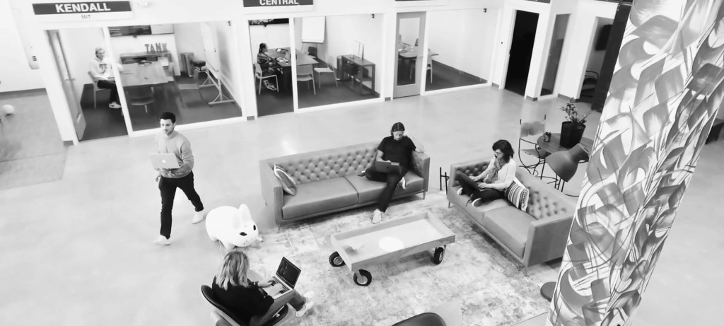 Team collaborating and relaxing in a lounge, discussing workflows for a digital solution.