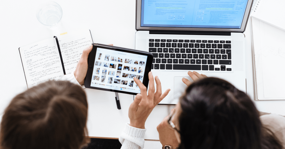 Two people collaborating on a tablet and laptop