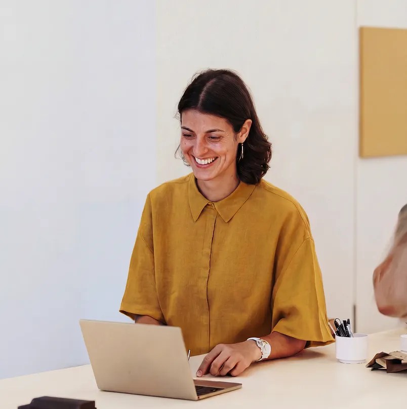 Consultant smiling while working on a laptop during an enterprise WordPress implementation project with a WordPress VIP service partner.
