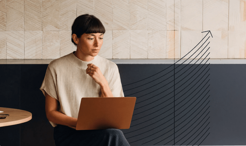 Person seated with a laptop, focused on their work, alongside an upward-trending graph illustration representing business growth, performance, and digital success.
